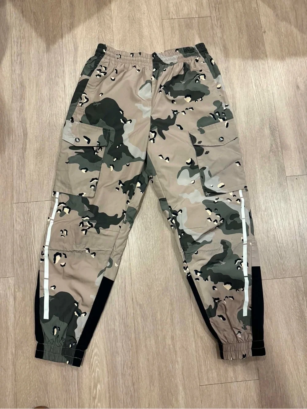 Paper Planes multi-pocket cargo pants featuring an all-over camouflage print